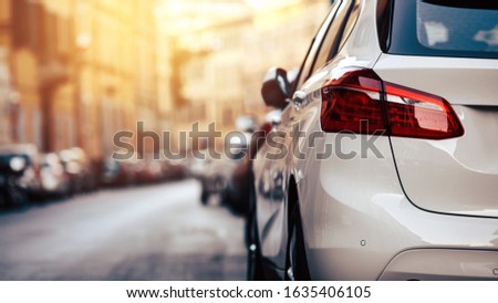Car parking on the street. Modern white car close-up red headlights banner background. 
