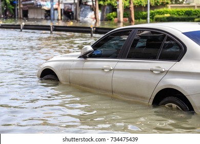 Car parking on the street and show level of water flooding in Bangkok, Thailand - Shutterstock ID 734475439