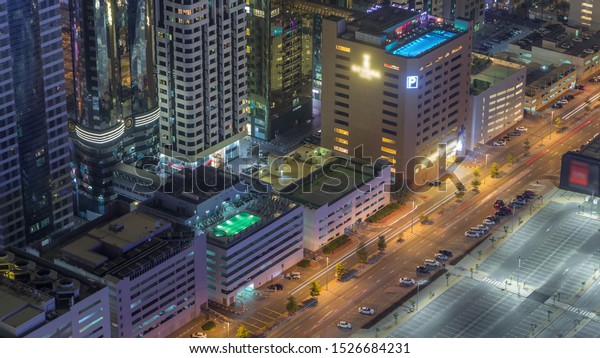 Car parking lot with rooftop swimming pool\
viewed from above night timelapse, Aerial top view at financial\
district. People relaxing. Dubai,\
UAE