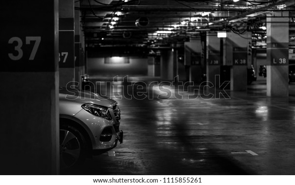 Car parking in the shopping mall. Silver\
car parked at block 37 overnight. Indoor car parking. Automobile\
parking space. Underground car parking lot. Robbery auto parked in\
a deserted place concept.