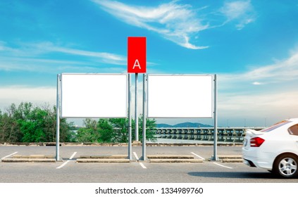 Car Parking Space And Empty Advertising Board Near The Sea, Mountain And Concrete Bridge. White Car  Driving On Asphalt Road In Parking Lot Area For Rental Service Zone A. Automotive Industry.