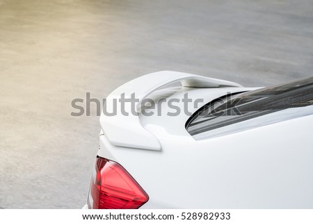 Car part ; Close up detail of a custom racing carbon fiber spoiler on the rear of a modern car with copy space

