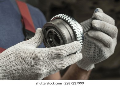 Car parts. Constant velocity drive. The structural element of the front suspension of the car. Before installation, a new spare part is in the hands of an auto mechanic. - Shutterstock ID 2287237999