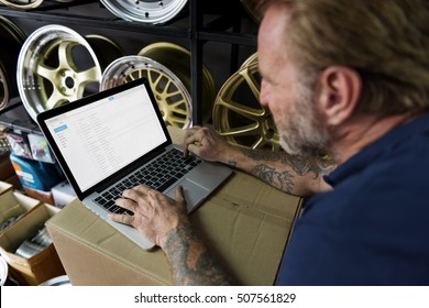 Car Parts Shop Owner Warehouse Checking Emails Concept