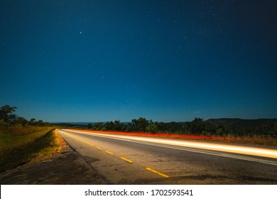 A Car Passes By On A Highway At Night.