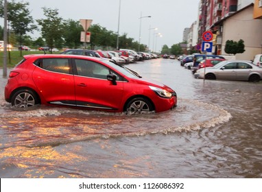 The Car Passes Through A Flooded Street, Damage After A Storm.