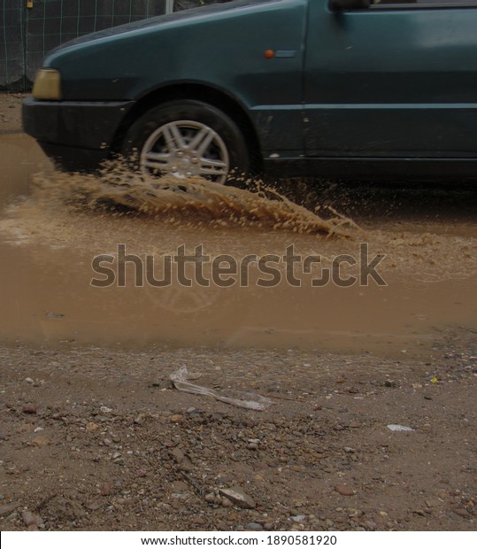A car passes\
through puddles during the\
rain