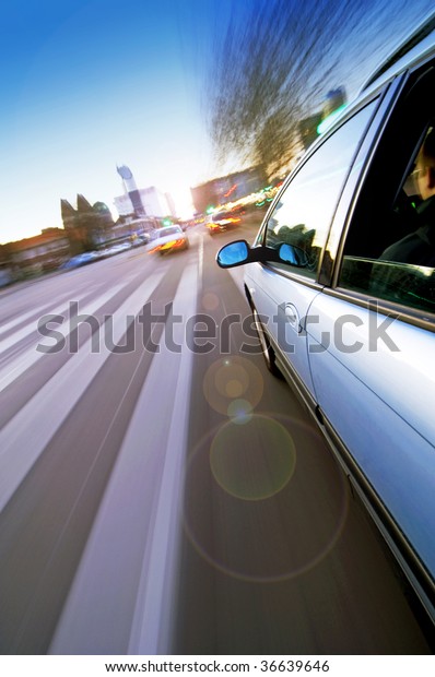 A car passing a pedestrian\
crossing in an urban environment, seen from the outside of the\
car