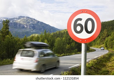 Car passing speed limit sign