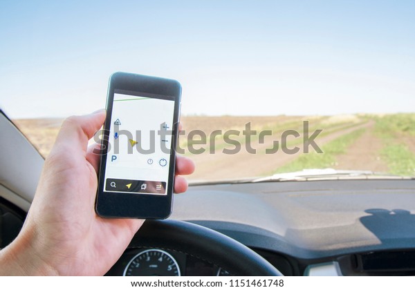 Car with phone navigator on a country road in\
summer. View from inside the\
car.