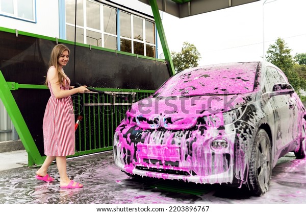 car in pink foam standing at a self-service
car wash. car cleaning. removing dirt from the car. preparation for
sale. washing for electric
cars
