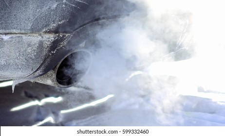 Car Pipe Puffs Out Exhaust Gas Clouds. Smoke Clouds Coming Out Of Automobile Tailpipe. Air And Environment Pollution By Vehicle Closeup Shot.