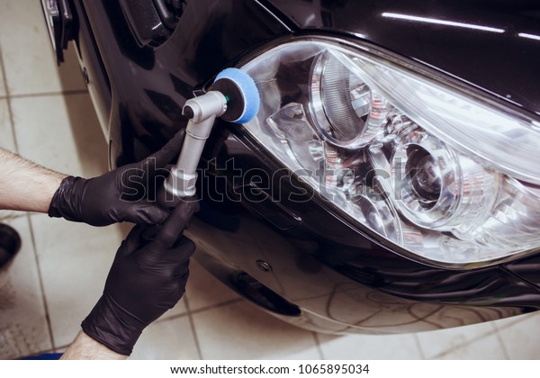 Car polish wax worker hands holding\
polisher and polish car detailing or valeting\
concept
