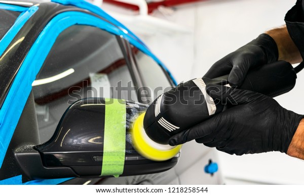 Car\
polish wax worker hands applying protective tape before polishing.\
Buffing and polishing car. Car detailing. Man holds a polisher in\
the hand and polishes the car. Polishing\
concept