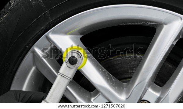Car polish wax worker hands\
polishing wheel. Buffing and polishing car disk. Car detailing. Man\
holds a polisher in the hand and polishes the car. Tools for\
polishing