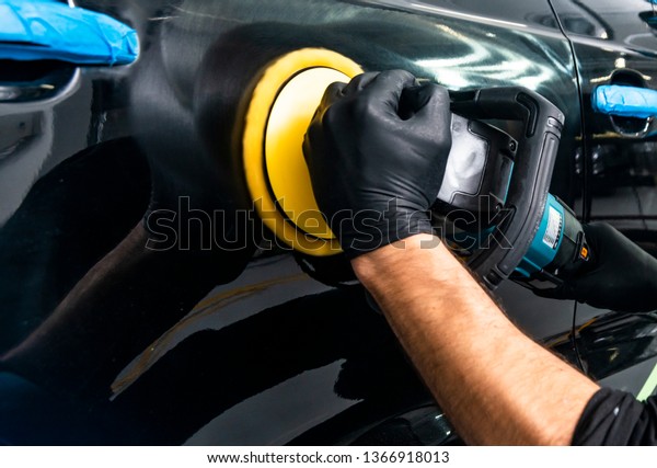 Car\
polish wax worker hands applying protective tape before polishing.\
Buffing and polishing car. Car detailing. Man holds a polisher in\
the hand and polishes the car. Tools for\
polishing