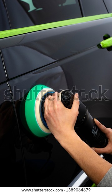 Car polish\
wax worker hands polishing car. Buffing and polishing vehicle with\
ceramic. Car detailing. Man holds a polisher in the hand and\
polishes the car. Tools for\
polishing