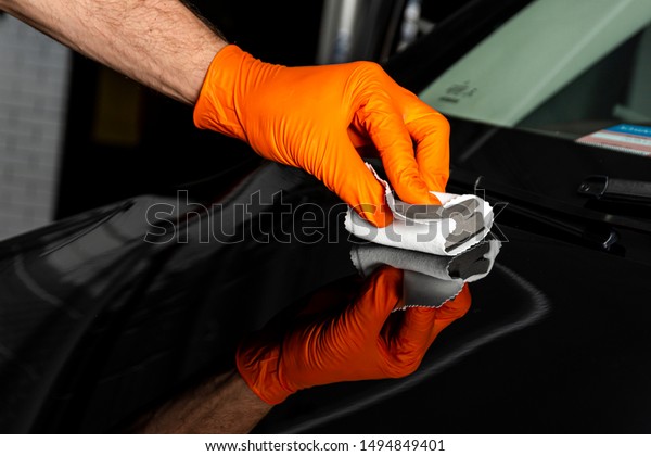 Car polish wax worker hands polishing car.\
Buffing and polishing vehicle with ceramic. Car detailing. Man\
holds a polisher in the hand and polishes the car with nano\
ceramic. Tools for\
polishing