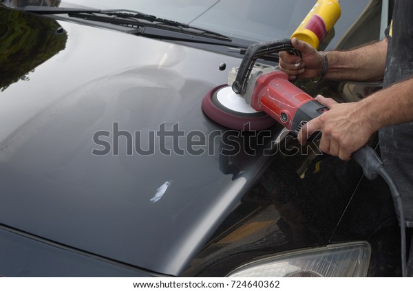 Car polish\
wax. worker hands holding a polisher.\
