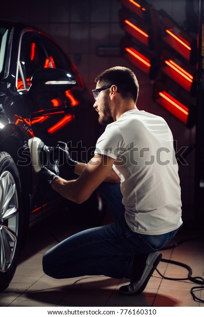 Car polish wax. worker hands holding a polisher and\
polish car