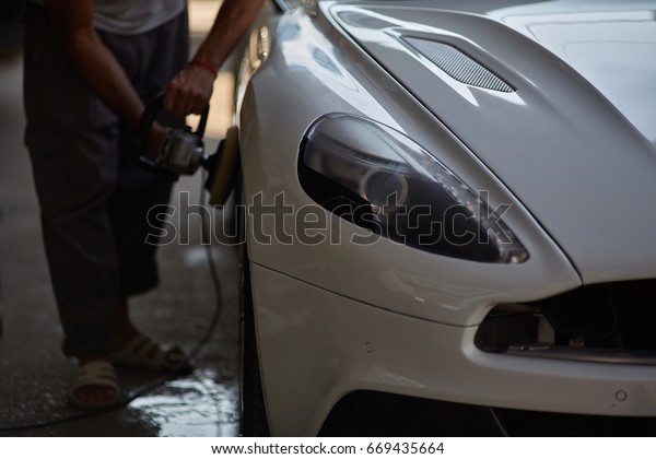 Car\
polishing series : Worker waxing white car\
door