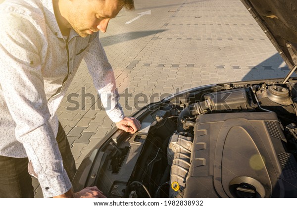 Car problem. Driver man near open hood auto after\
accident triangle on road. Vehicle broken down or motor car engine\
problem concept