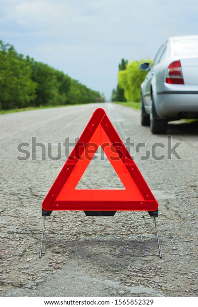 Car with problems and a red triangle to warn other
road users