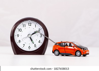 Car pulling clock hand forward in abstract time management concept. - Shutterstock ID 1827658013