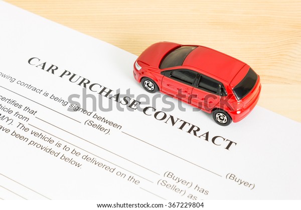 Car purchase contract with\
red car on right view. Auto purchase agreement or legal\
document