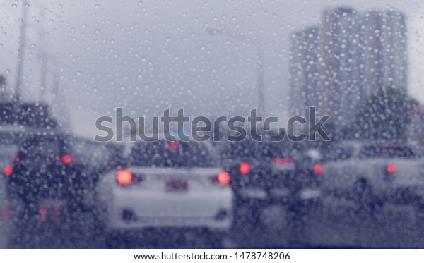Car in rainy road in the dark evening with\
drizzle on the windshield. Cars driving in the heavy rain and\
slippery road .Dangerous transportation and bad weather for\
vehicle, blurred\
background\
