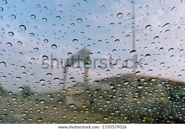 Car in rainy road with drizzle on the\
windshield window. Cars driving in the heavy rain and slippery road\
with traffic jam. Dangerous transportation and bad weather,raining\
blurred background.