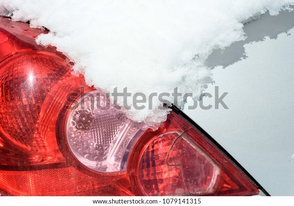 Car rear view light and\
indicator covered and obscured in a thick blanket of winter snow.\
Copy space area for extreme weather travel and transport concepts\
and ideas