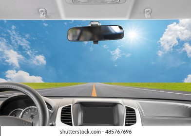 Car Rear View Mirror Inside The Car And Drive A Car On Road With Blue Sky Background.