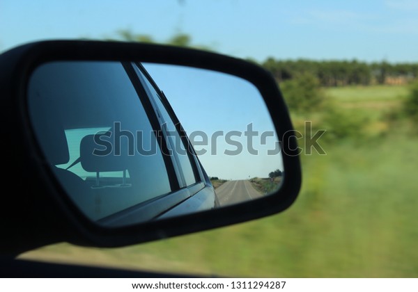 car rear\
view mirror and landscape in the\
window