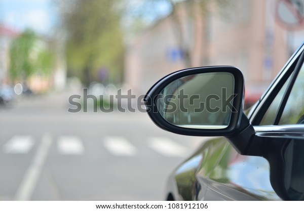 Car rear view\
mirror on the city\
background.