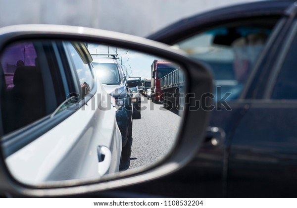 Car rear view mirror with\
reflection of the traffic flow in the tube. Concept: modern rhythm\
of life.