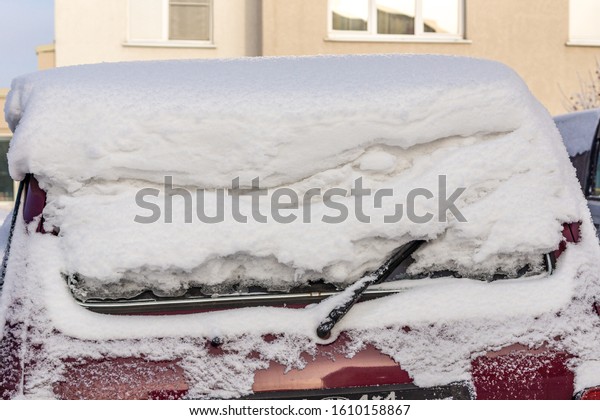 car rear window covered with a large layer of snow,\
car covered with snow