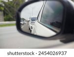 car rearview mirror that reflects the vehicle behind it on the toll road