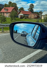 Car Reflection in Side Mirror on Rural Road