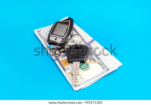 Car\
remote control with money on a blue\
background.