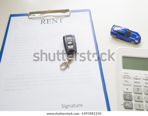 A car rent service lease contract with key\
and calculator.