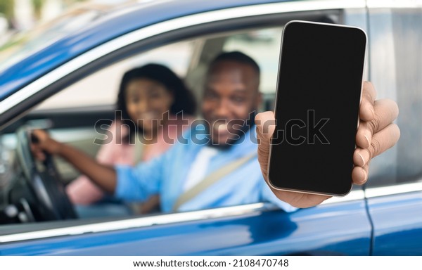 Car Rental App. Black Family Sitting In Auto
Showing Smartphone With Blank Screen, African American Tourists
Couple Demonstrating Empty Mobile Phone While Riding New Vehicle,
Collage, Mockup