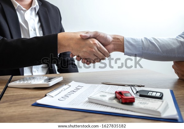 Car rental and Insurance concept, Young
salesman shaking hands after finishing up a collaboration
discussing with customer after sign agreement contract with
approved good deal for rent or
purchase.
