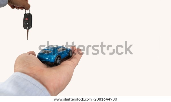 Car rental and sale concept. Agent hands to\
hand over car keys on white\
background.