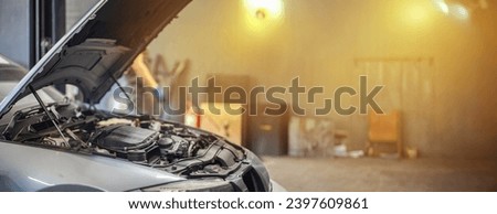 car repair concept in a car service center, open car hood in a garage. 
