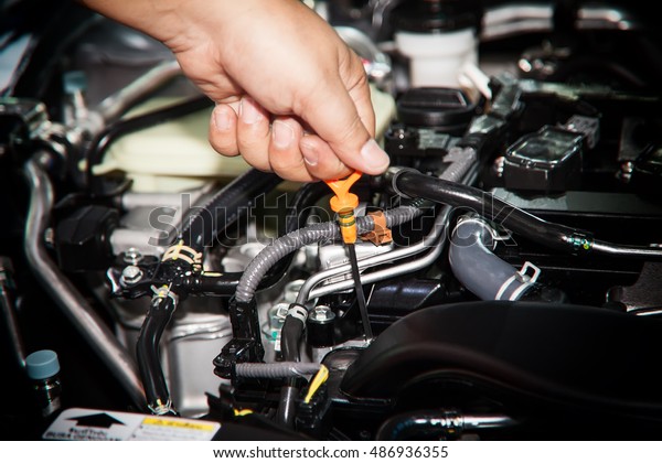 Car repair service, Auto mechanic checking oil\
level in a engine