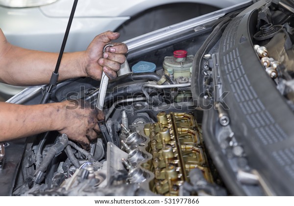 Car repair service, Auto mechanic repairing car\
engine in the garage
