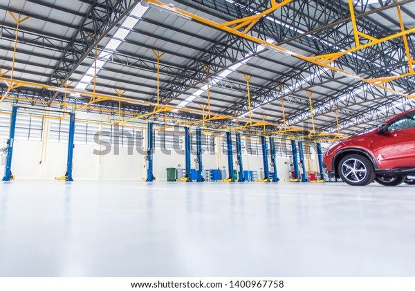Car repair service center the epoxy floor in car\
factory service  , The interior of a big industrial building or\
factory with steel constructions.,Steel roof frame , blurred\
background for industry