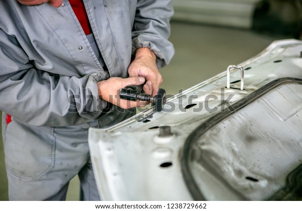 Car repair in car service. Locksmith grinds car
detail, hands close-up