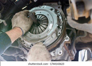 Car repair in a car service. Replacing the clutch disc of a gearbox on a car at a service station. Hands of a professional car mechanic. Cars repair technology. Technical photography. - Shutterstock ID 1744143623